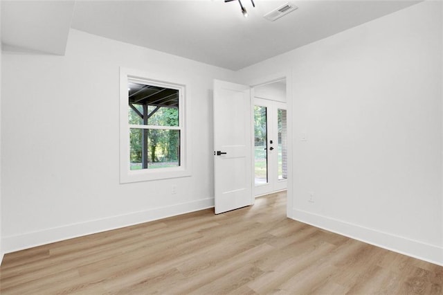 spare room featuring light hardwood / wood-style flooring and a healthy amount of sunlight