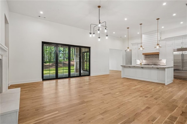 4235 Drew Campground Rd, Alpharetta, GA 30004 - unfurnished living room with baseboards, recessed lighting, light wood-style flooring, and a high ceiling
