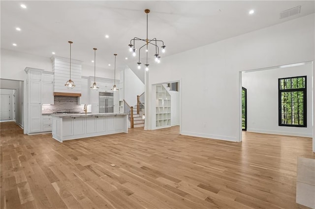4235 Drew Campground Rd, Alpharetta, GA 30004 - unfurnished living room with light wood finished floors, recessed lighting, stairs, a chandelier, and baseboards
