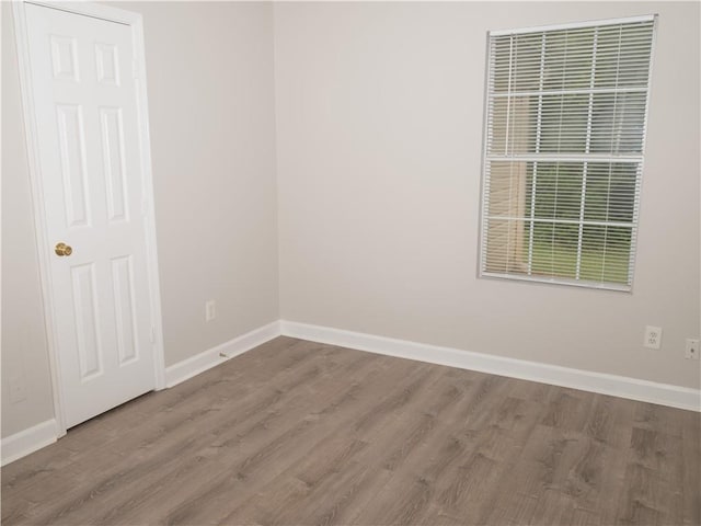 empty room featuring baseboards and wood finished floors