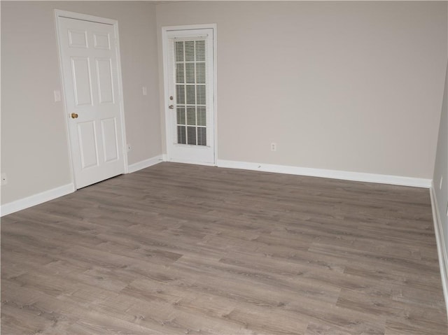 unfurnished room featuring baseboards and wood finished floors