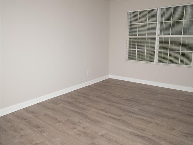 empty room featuring wood finished floors and baseboards