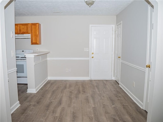 unfurnished dining area featuring a textured ceiling, baseboards, visible vents, and light wood-style floors