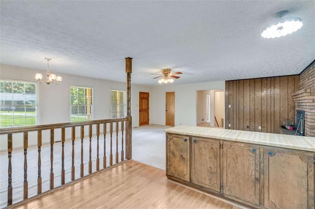 3740 Windy Hill Cir, Gainesville, GA 30504 - kitchen with a textured ceiling, a ceiling fan, tile countertops, light wood-style flooring, and a chandelier