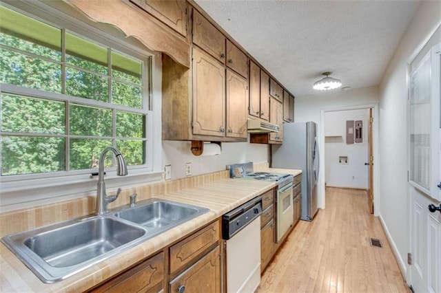 3740 Windy Hill Cir, Gainesville, GA 30504 - kitchen with white appliances, a sink, under cabinet range hood, brown cabinets, and light countertops
