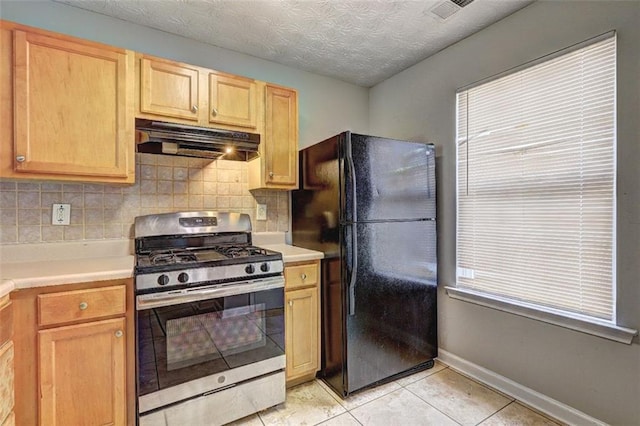 3216 Panthers Trce, Decatur, GA 30034 - kitchen with light tile patterned flooring, stainless steel gas range oven, freestanding refrigerator, backsplash, and under cabinet range hood