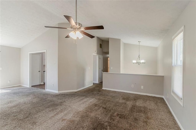 carpeted spare room featuring ceiling fan with notable chandelier, baseboards, and a textured ceiling