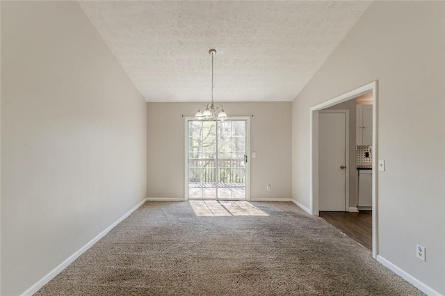 spare room with an inviting chandelier, carpet, baseboards, and a textured ceiling