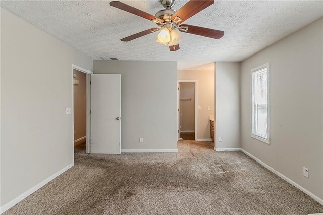 unfurnished bedroom with baseboards, carpet floors, a textured ceiling, and ceiling fan