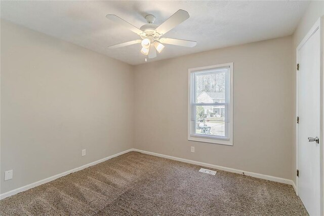 carpeted empty room featuring visible vents, baseboards, and ceiling fan