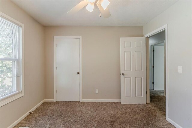 unfurnished bedroom featuring baseboards, carpet floors, and ceiling fan