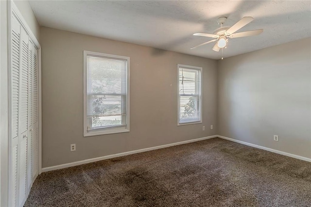 unfurnished bedroom with baseboards, carpet flooring, ceiling fan, and a closet