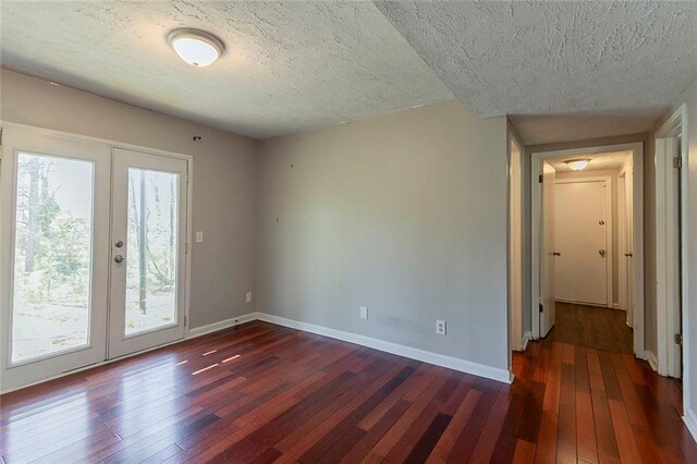 unfurnished room featuring dark wood finished floors, baseboards, french doors, and a textured ceiling