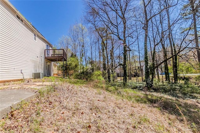 view of yard featuring a wooden deck and central AC