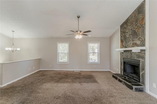 unfurnished living room with ceiling fan with notable chandelier, a fireplace, carpet floors, and baseboards