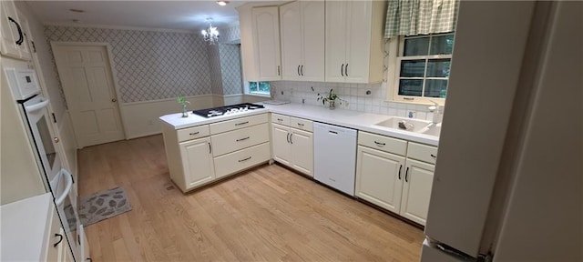 2600 Amberly Dr, Dunwoody, GA 30360 - kitchen featuring white appliances, wallpapered walls, a sink, a peninsula, and white cabinets