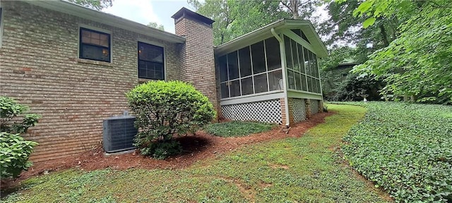 2600 Amberly Dr, Dunwoody, GA 30360 - view of side of home featuring a sunroom, a chimney, central air condition unit, and brick siding