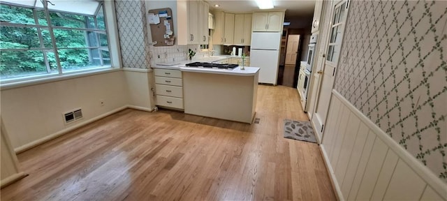 2600 Amberly Dr, Dunwoody, GA 30360 - kitchen with freestanding refrigerator, a peninsula, light wood-style floors, and light countertops