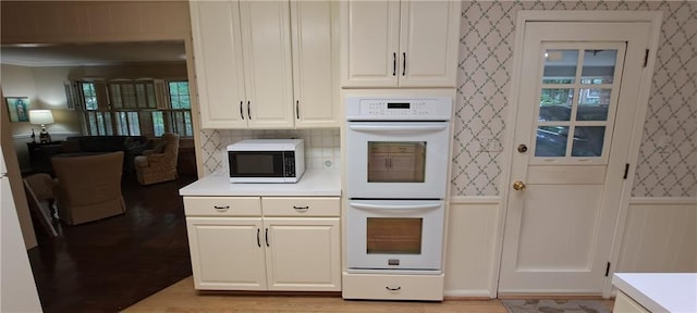 2600 Amberly Dr, Dunwoody, GA 30360 - kitchen featuring white appliances, a wainscoted wall, light countertops, wallpapered walls, and light wood finished floors