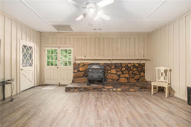 178 Garrison St, Homer, GA 30547 - unfurnished living room with a wood stove, wood finished floors, a ceiling fan, and wooden walls