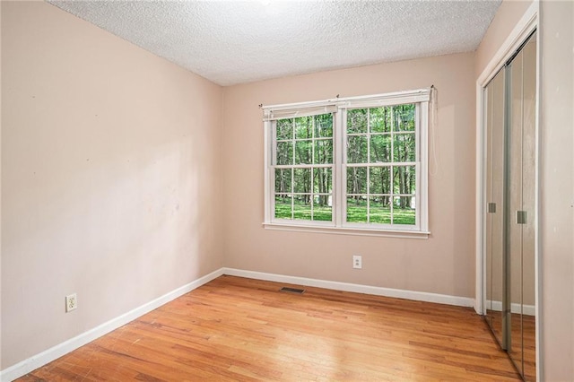 178 Garrison St, Homer, GA 30547 - unfurnished bedroom with light wood-type flooring, a textured ceiling, and a closet