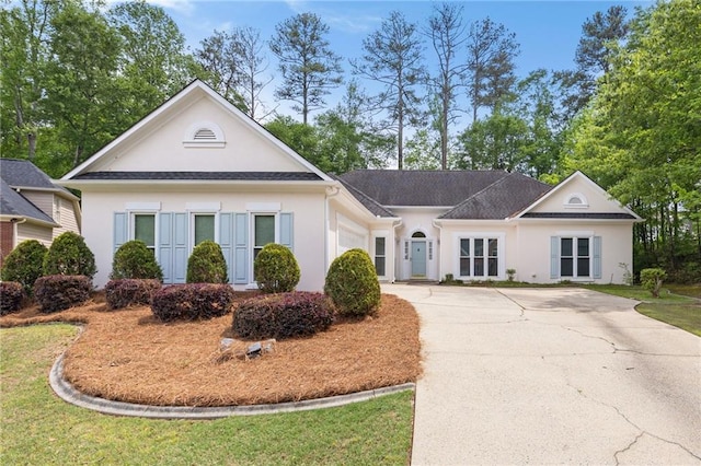 view of front of house with a garage, stucco siding, concrete driveway, and a front yard