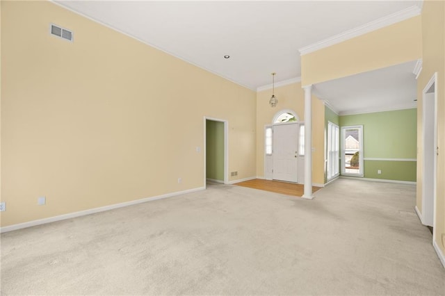spare room featuring baseboards, visible vents, ornamental molding, and light carpet