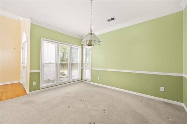 spare room featuring crown molding, baseboards, visible vents, and carpet