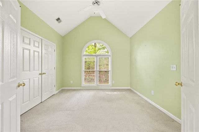 unfurnished bedroom featuring visible vents, light carpet, baseboards, a ceiling fan, and vaulted ceiling