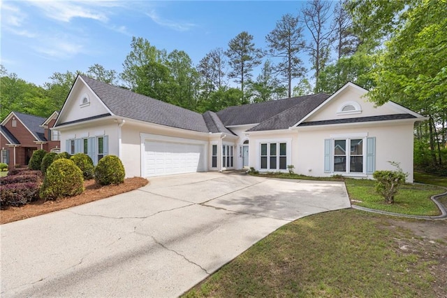 single story home with stucco siding, an attached garage, driveway, and a front lawn