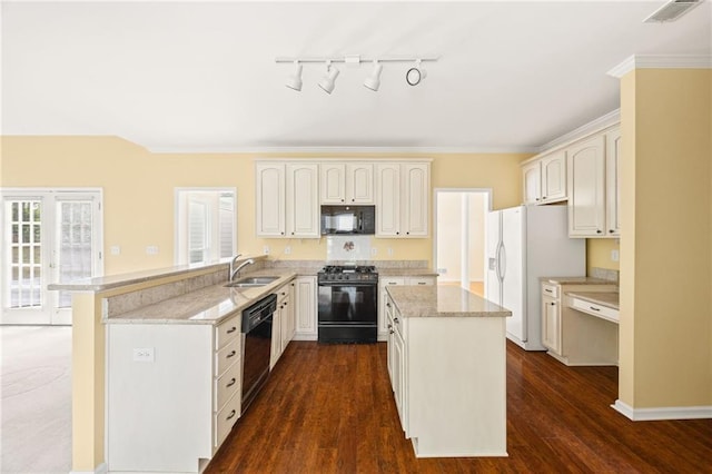 kitchen featuring visible vents, a peninsula, a kitchen island, a sink, and black appliances