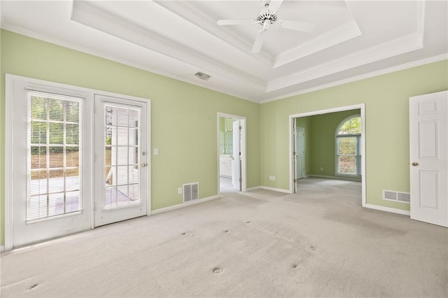 unfurnished room featuring carpet flooring, a tray ceiling, visible vents, and ornamental molding