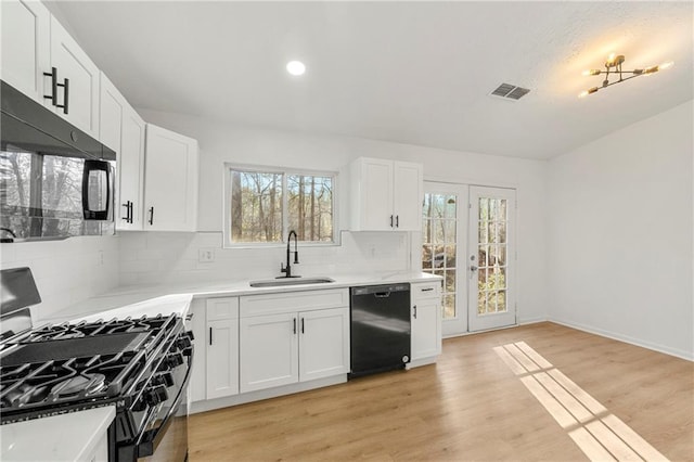 kitchen with range with gas cooktop, light countertops, white cabinetry, a sink, and dishwasher