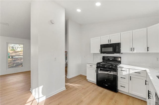 kitchen featuring black appliances, decorative backsplash, white cabinets, and lofted ceiling