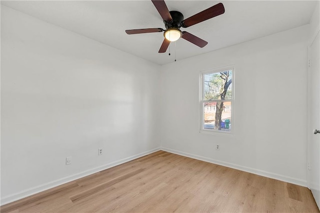 spare room featuring light wood finished floors, ceiling fan, and baseboards