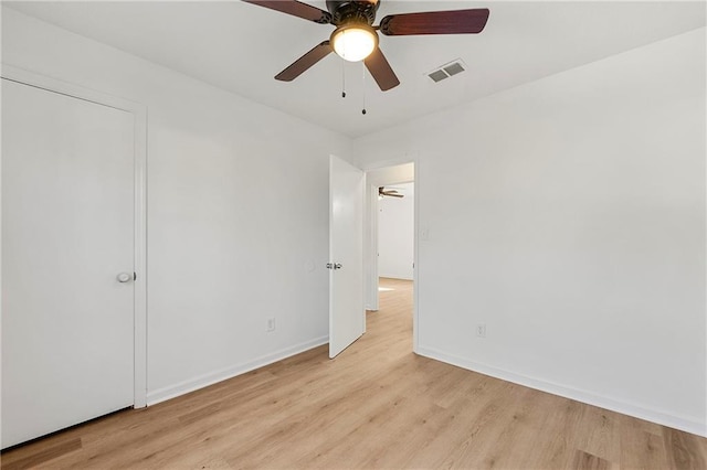 unfurnished bedroom featuring light wood finished floors, baseboards, visible vents, and ceiling fan