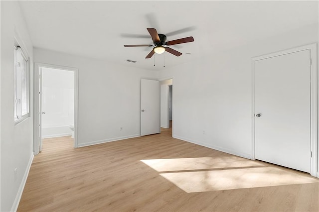 unfurnished bedroom with ensuite bathroom, a ceiling fan, visible vents, baseboards, and light wood-type flooring