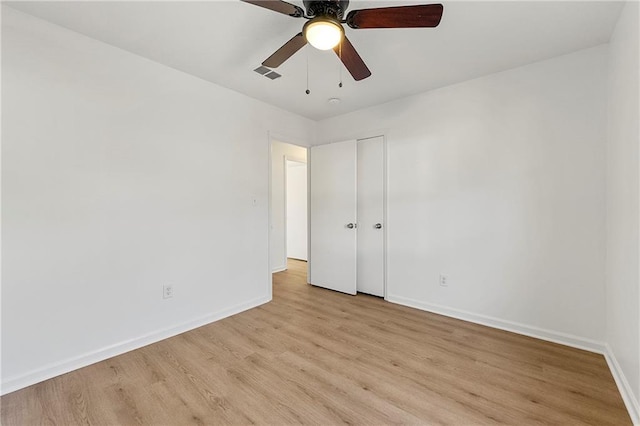 unfurnished bedroom with a closet, visible vents, a ceiling fan, light wood-type flooring, and baseboards