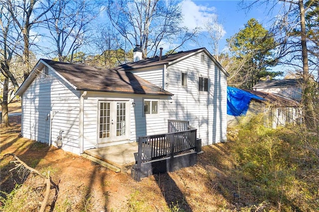 rear view of house featuring a wooden deck, a chimney, and french doors