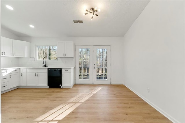 kitchen with dishwasher, white cabinets, french doors, and sink