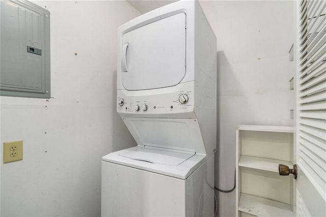 clothes washing area featuring stacked washer and clothes dryer and electric panel