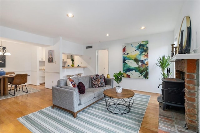 living room with a wood stove and light wood-type flooring