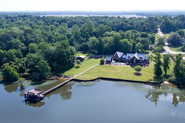 view from above of property with a nearby body of water and a forest