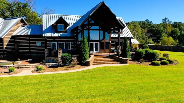 rear view of house featuring french doors, a lawn, and metal roof