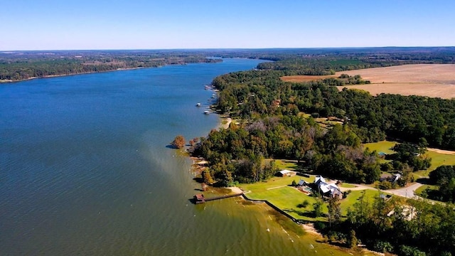 aerial view of property's location featuring a large body of water and a heavily wooded area