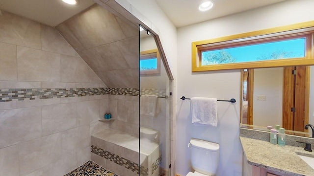 bathroom with toilet, a tile shower, recessed lighting, and vanity
