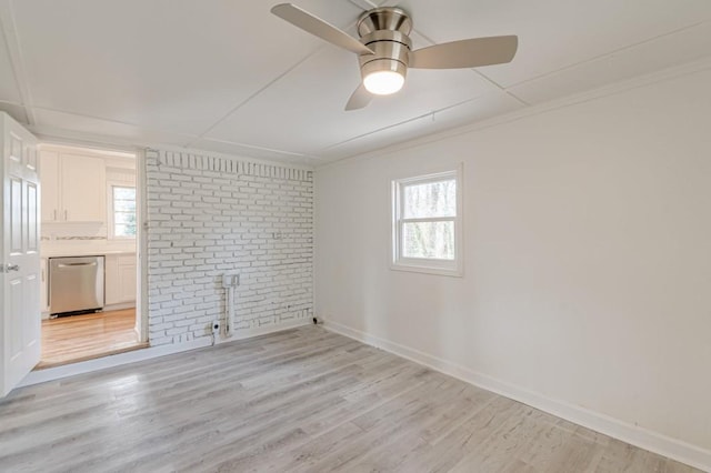 unfurnished room featuring crown molding, brick wall, ceiling fan, and light hardwood / wood-style floors