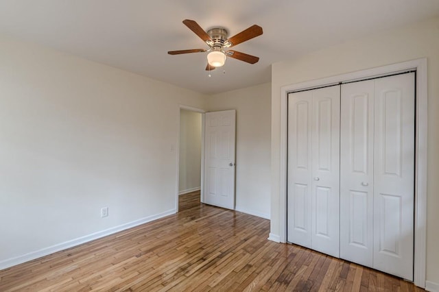 unfurnished bedroom with ceiling fan, light wood-type flooring, and a closet