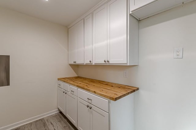 interior space with wood counters, white cabinetry, and light hardwood / wood-style floors