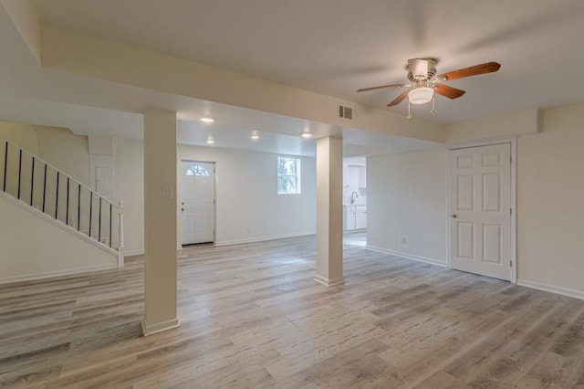 basement with light hardwood / wood-style flooring and ceiling fan